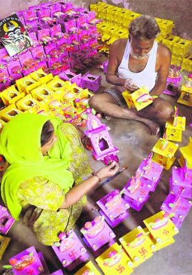 A couple gives finishing touches to traditional mud huts for Diwali in Patiala