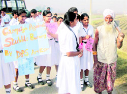 Students of DPS engage in a discussion with a farmer at Manawala village near Amritsar on Thursday