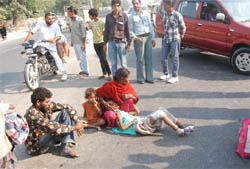 Family members of Sapna squat along with her on the main road outside the Civil Hospital in Bathinda on Thursday.