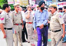 A policeman takes away the security guard from whose weapon the gunshot was fired accidently. 