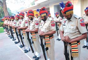 Policemen reverse their arms to pay respects to the martyrs to mark the Commemoration Day function at the Police Lines in the city on Friday.