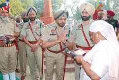 IG, Bathinda zone, Nirmal Singh Dhillon presents a memento to the kin of a martyr at the Commemoration Day function held on Friday.