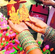A woman selects statues of Goddess Lakshmi and Lord Ganesh for Diwali in Karnal on Saturday.