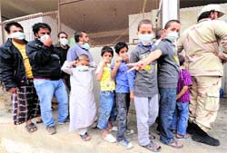 Libyan men and children queue up to have a look at the corpse of Muammar Gaddafi outside a cold store in a vegetable market on the outskirts of Misrata