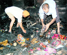 Men sift through the debris at the cracker shop-cum-godown where a major fire broke out at the Mahan Singh Gate market in Amritsar on Saturda