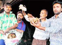 People show cash recovered from the debris