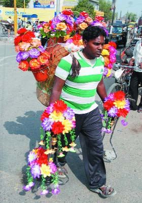 Floral burden!: A florist on way to earn his livelihood on the Mall Road in Bathinda on Sunday