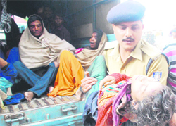 An injured passenger being taken to the government hospital in Jammu on Sunday; and (right) police and rescue officials at the mishap site in Nandini, some 20km from Jammu.