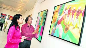 Visitors take a look on a painting by artist Arjun at an exhibition at the Virsa Vihar in Jalandhar. 