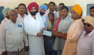 Parminder Singh handing over a cheque of Rs 25 lakhs for the development of Leprosy Colony.