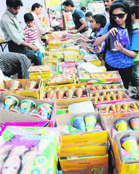 People busy shopping for crackers in the Sector 26 market, Chandigarh, on Monday