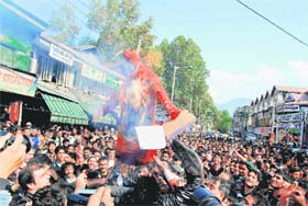 PDP workers burns an effigy representing corruption during a protest in Srinagar on Monday