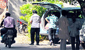 A resident who brought quilts for an employees of the DTO office hides them in a SUV outside the Mini-Secretariat on Monday.