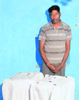 The accused, Khan Singh, with sealed boxes of the contraband, in Fazilka on Monday.