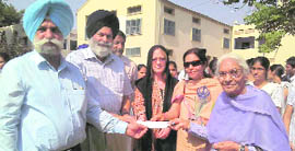 Shivinderpal Kaur (right) hands over a cheque of Rs 40 lakh to college principal