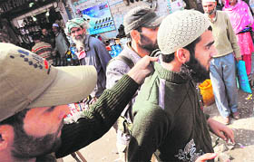 Police detain a man for questioning in Srinagar.