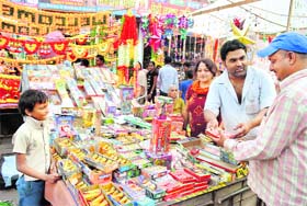A customer tries to strike a deal at a cracker shop on the eve of Diwali at a market in Patiala on Tuesday