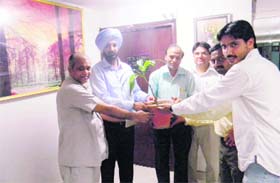 PPCB chief KS Pannu (2nd from L) presents a sapling to a staffer