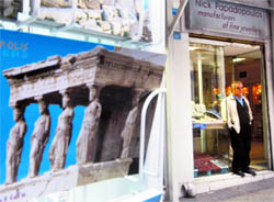A shop owner stands at the entrance of his empty shop in Athens on Thursday