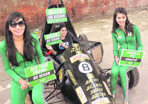 People for the Ethical Treatment of Animals (PETA) activists pose as pit crew with a racing car during a promotional event in New Delhi on Thursday. 