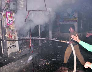 A fireman tries to douse flames at a bakery in Laxmipura on Wednesday night. 