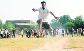 A job aspirant jumps during the recruitment drive by the Mohali police on Friday. 