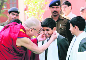 The Dalai Lama lovingly pulls the ears of a young student at the Founders Day function of The Doon School in Dehradun on Friday. 