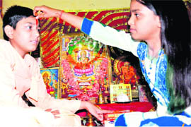 A girl applies tilak on the forehead of her brother on Bhaiya Dooj in Pauri Garhwal on Friday.