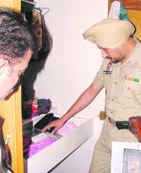 A policeman looks for clues on Friday in the house of Raj Kumar where a theft took place on Thursday night. 
