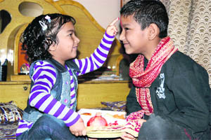 A sister applies tilak on her brother’s forehead on Bhai Dooj in Ludhiana on Friday.