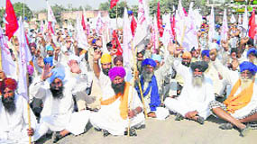 Farmers and workers block a road in Tarn Taran on Saturday. 