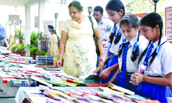 Residents and schoolchildren take a look at books displayed at the stalls during the mela in Jalandhar. 