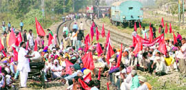 Members of farmer organisations squat on railway tracks at Phillaur on Saturday.