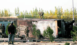 US troops prepare to remove the wreckage of a bus hit by a suicide bomber in Kabul on Saturday