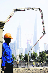A worker at the entrance of a new building site in Shanghai on Sunday. Europe has set its sights on Beijing as it tries to pull itself out of a debt crisis, but many Chinese are asking why they should bail out wealthier nations that have lived beyond their means. 