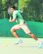 Himanshu Mali rushes to play a return against Rohan Bhatia during their tennis match in Chandigarh on Sunday.