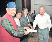 Uttarakhand Chief Minister B.C. Khanduri presents a cheque to an ex-serviceman at a rally of ex-servicemen held at Srinagar, Garhwal, on Sunday.