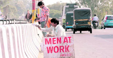 Workers paint parapets on the Tawi Bridge in Jammu on Sunday.