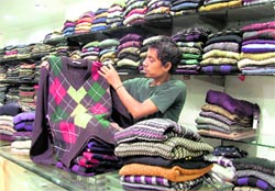 A salesman displays woollens in a retail outlet at Ghumar Mandi in Ludhiana