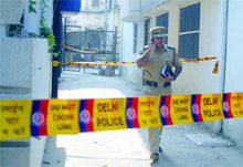 A Delhi police official investigates the muder of a woman at Jangpura in New Delhi on Monday