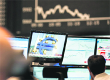 A trader sits in front of screens at the Frankfurt Stock Exchange on Tuesday. Germany's blue-chip DAX 30 stocks index sank more than 5.0% in midday trade amid turmoil set off by the shock announcement of a Greek referendum on last week's EU debt rescue package 