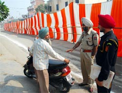 A policeman asks a person not to park his motorbike on a road near the sports stadium in Bathinda on Tuesday