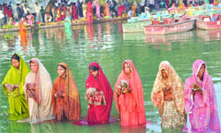 Devotees offer prayer to the Sun god during the Chhath pooja on the banks of Boat Club near India Gate in New Delhi