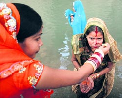 Women perform rituals during Chhath Puja in Jammu on Tuesday