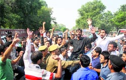 Students protest outside the University of Jammu on Tuesday against the new recruitment policy of the state government
