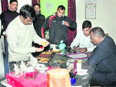 Vigilance officials examine the articles seized from Dharam Singhs residence in Dehradun on Tuesday.