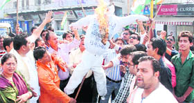 Members of the Congress burn an effigy of the BJP government at Prince Chowk in Dehradun on Tuesday. 