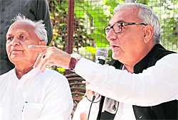 Chief Minister Bhupinder Singh Hooda elaborates a point on the Maruti issue at a press conference in Chandigarh on Wednesday as state Congress chief Phool Chand Mullana looks on. 