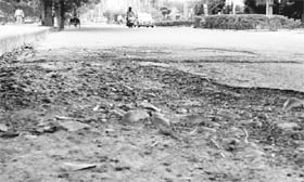 The damaged portion of a road poses a threat to the lives of commuters.