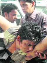 An injured youth carried by students at DAV PG College in Dehradun on Thursday. 
